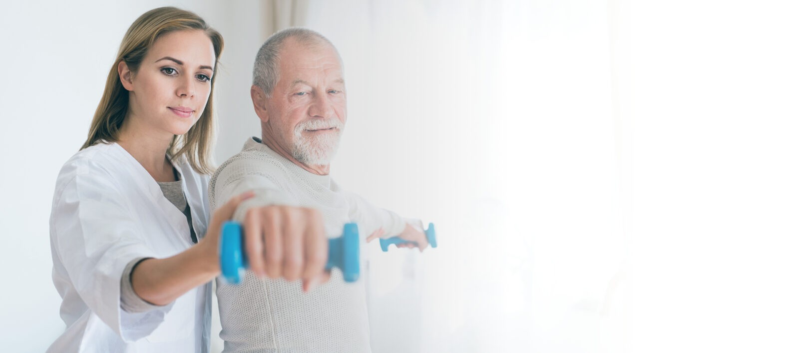 Female Home Caregiver Helps Elderly Man With Dumbell Training
