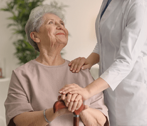 Home Care Helper Comforts Smiling Elderly Woman
