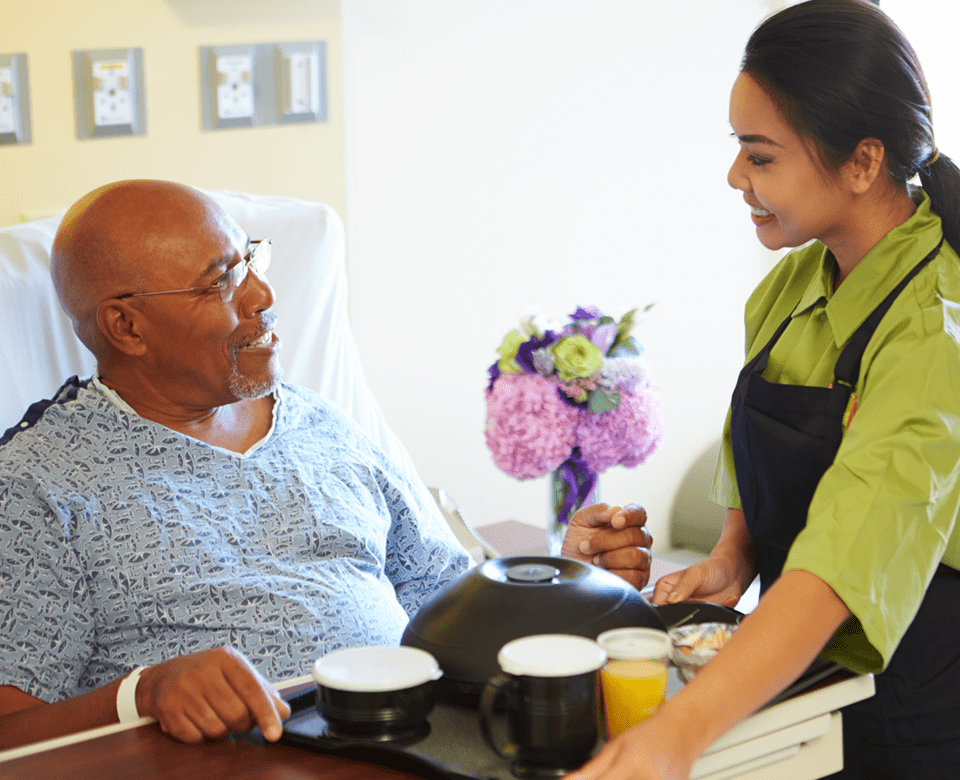 Home Care Helper Bringing Patient Food in Bed