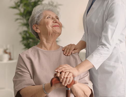 Home Care Helper Comforts Smiling Elderly Woman