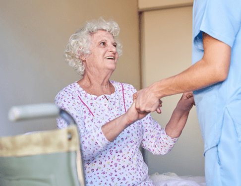 Home Care Worker Holds Hands with Senior Woman