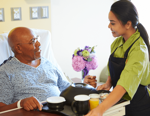 Home Care Helper Bringing Patient Food in Bed