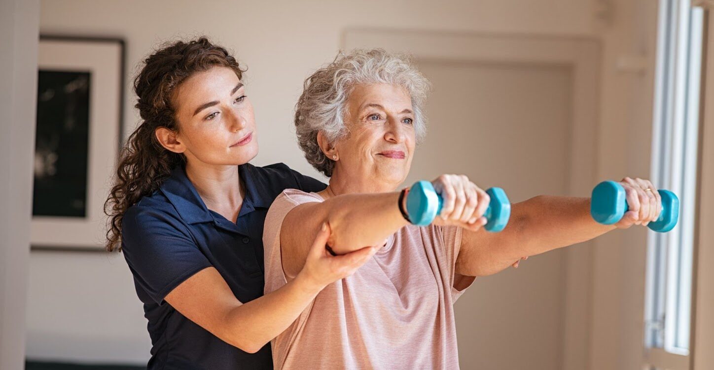 Elderly woman with Parkinson’s lifts enjoys the benefits of exercise in her own home.